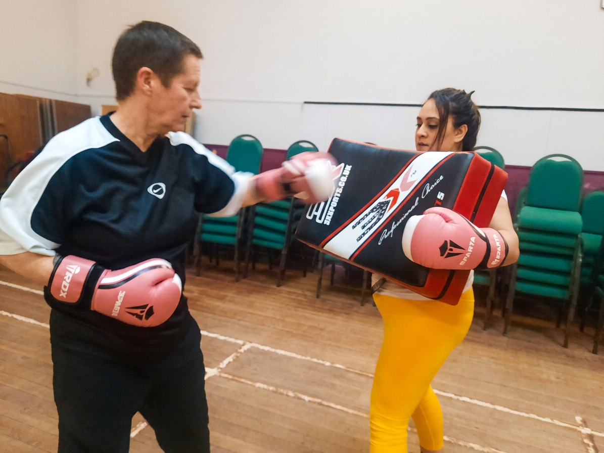 Women training with medicine ball at NCHF boxfit for women class Govanhill Glasgow